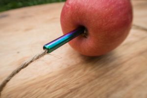 use a metal straw to thread string through your apple